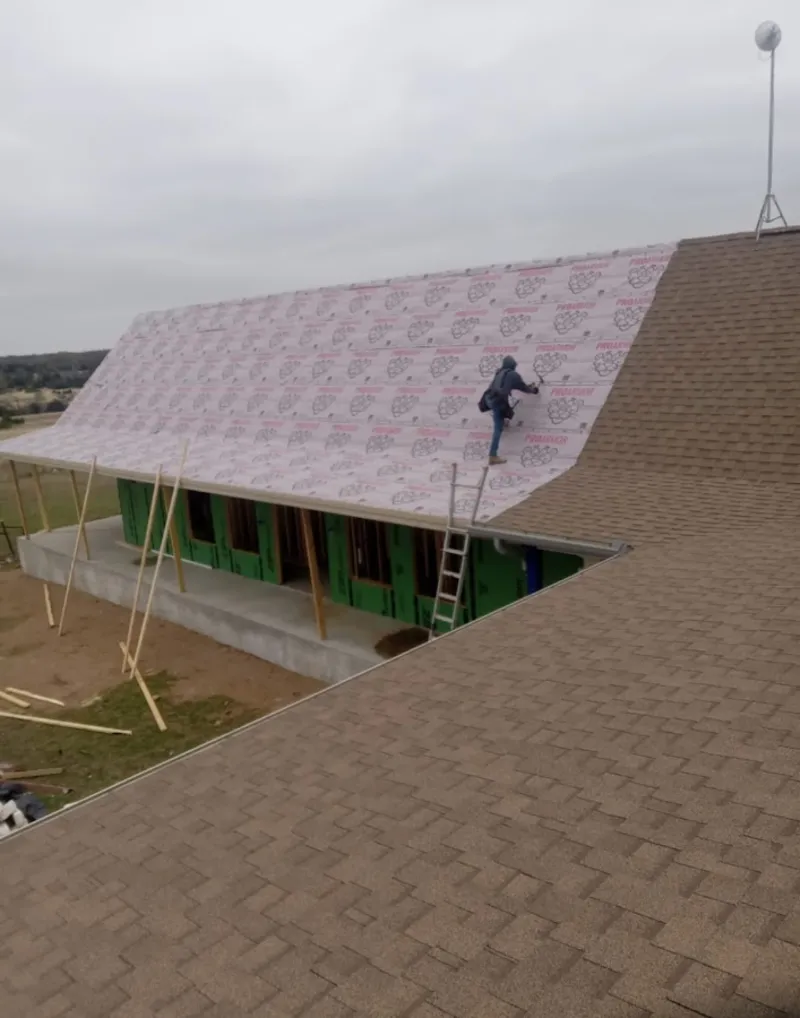 Worker preparing underlayment for a metal roof installation in Nephi